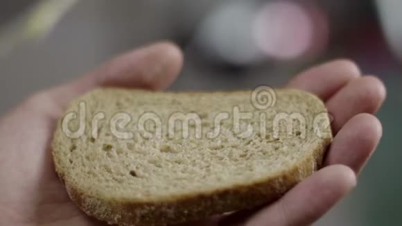 在厨房里雄性手的特写慢慢地在班布朗面包上铺上黄油视频的预览图