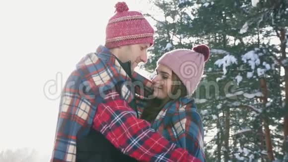 女孩和男人拥抱在阳光明媚的冬日森林里阳光照耀视频的预览图