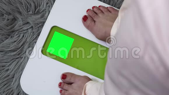 带有绿色屏幕的电子天平上的女人视频的预览图