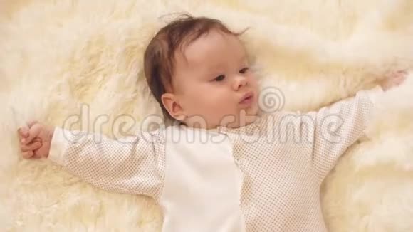 身体里的婴儿躺在他的背上用他的手玩视频的预览图