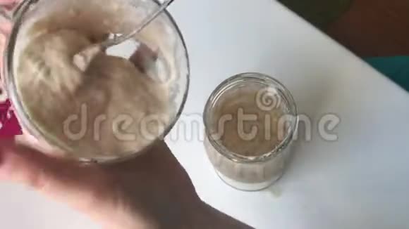 一名妇女在发酵发酵罐中加入水和面粉的混合物以供喂养视频的预览图
