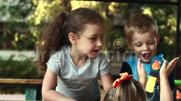 三个孩子在公园里在露天玩泡泡视频的预览图