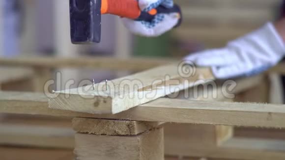 戴白手套的师傅用木制家具用木质材料作业主人把钉子钉进董事会视频的预览图