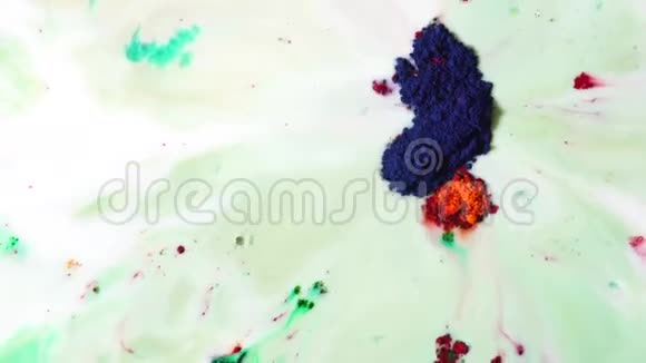 五颜六色的干墨漂浮在白色的牛奶中被吸进漏斗里绿色红色和深蓝色粉末涂料视频的预览图