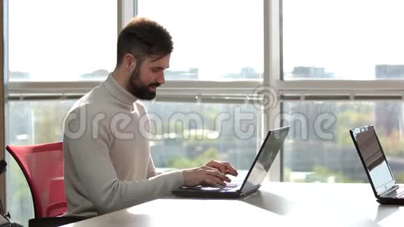 一个留着胡子的男人在笔记本电脑上思考视频的预览图