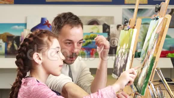 成熟的男画家帮他可爱的女儿画画视频的预览图