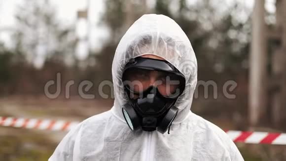 一个穿着生物危害防护服戴着防毒面具的男人径直走向镜头视频的预览图