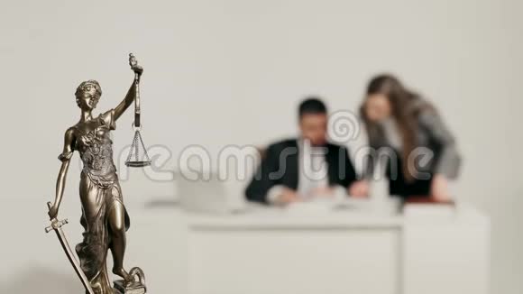 关于两个处理文件的人的背景的正义雕像视频的预览图