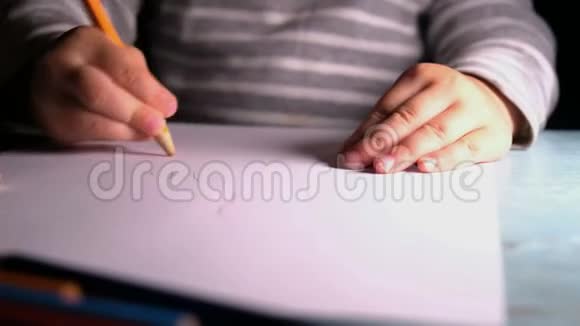 小孩子在一张纸上画一支黄色的铅笔特写视频的预览图