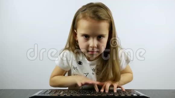 一个集中的女孩在键盘上打印直视着摄像机视频的预览图
