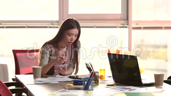 微笑的女孩从笔记本上的平板电脑重写信息视频的预览图
