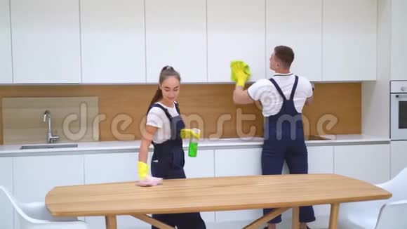 两个穿蓝色制服的年轻看门人打扫厨房视频的预览图