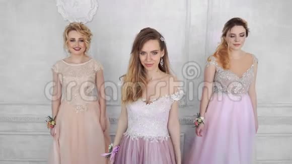 三个年轻的成年女孩穿着长长的晚礼服去看镜头视频的预览图