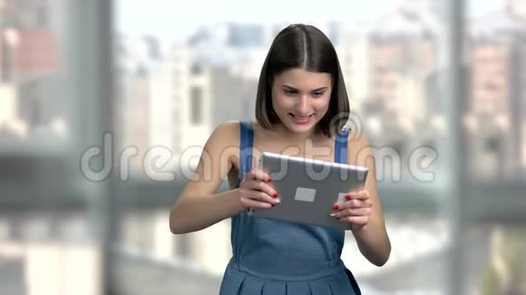迷人的女人在电脑平板电脑上玩视频的预览图