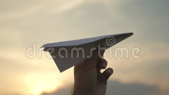 那人在如画的日落背景下举着纸飞机视频的预览图