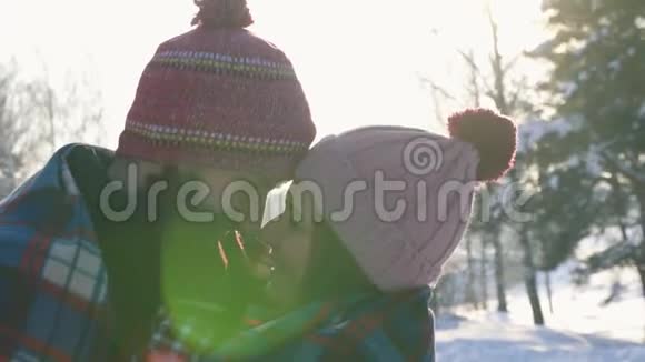 爱的女孩和男人在臂弯阳光明媚的冬日森林阳光闪耀视频的预览图