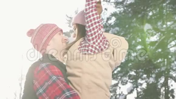 女孩和男孩在他们的怀里旋转阳光明媚白天冬天森林关闭视频的预览图