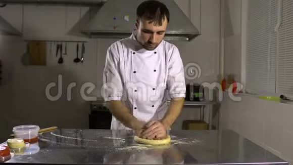 在厨房做饭准备一个圆面包产品旋转和揉捏他的手视频的预览图