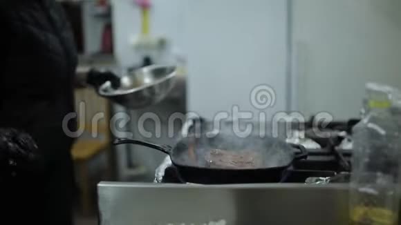 肉在烤锅上煎厨师在牛排上浇酱汁餐厅厨房准备牛排视频的预览图
