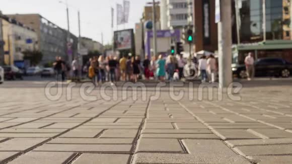 人群沿着人行横道穿过城市街道视频的预览图