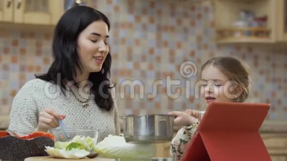 可爱的小女孩在厨房帮妈妈视频的预览图