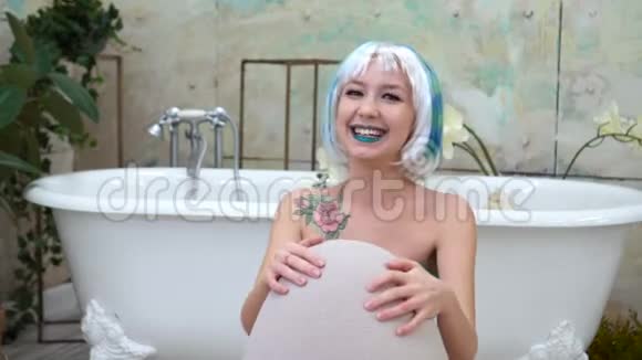 浴室里戴假发的快乐笑女的肖像视频的预览图