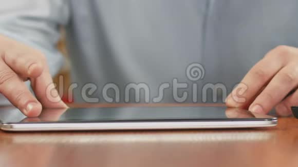 合上平板电脑上滚动的男性手在社交媒体上观看照片视频的预览图