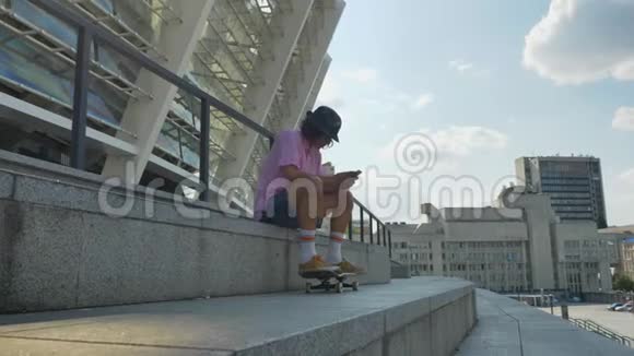 年轻人正在智能手机滑板城市观念交流观念侧视等上打字视频的预览图