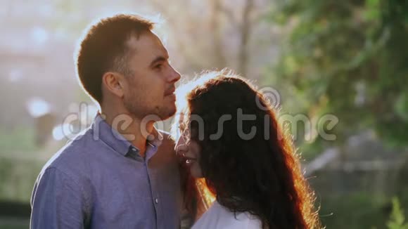 年轻漂亮的一对夫妇在秋天公园度过亲密的时光日落的光太阳耀斑喜欢约会的情侣视频的预览图