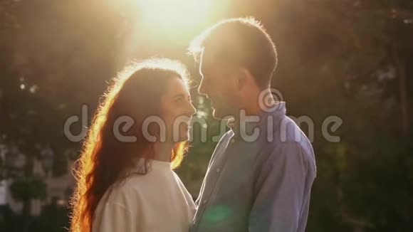 年轻漂亮的一对夫妇在秋天公园度过亲密的时光日落的光太阳耀斑喜欢约会的情侣视频的预览图