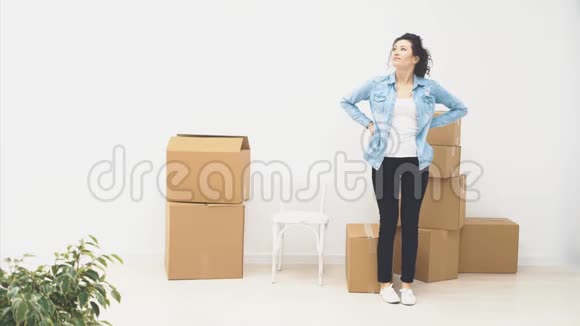 强壮的女人正在雕刻一个大的移动盒子里面装满了物品在白色的背景上被隔离4K视频的预览图