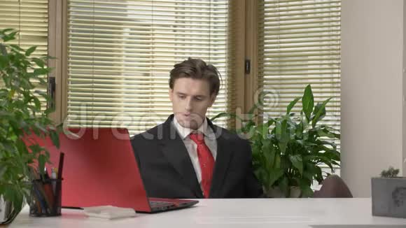 一个穿西装的年轻人正坐在办公室里试图为美式足球扔一个球喜剧幽默体育视频的预览图