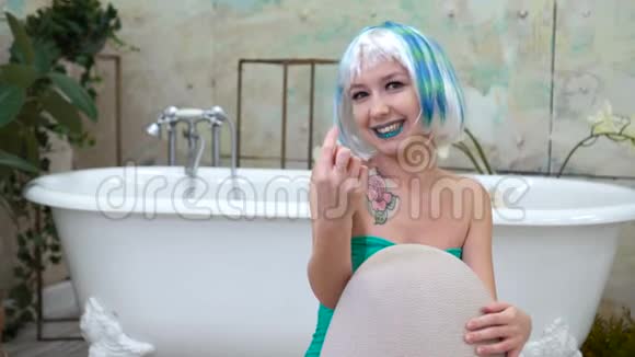 戴假发的女人在浴室里做召唤手势视频的预览图