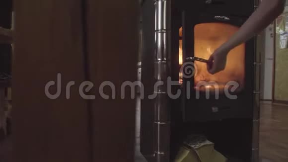 男人把木柴放进炉子里视频的预览图