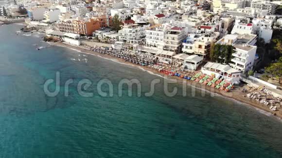 酒店市政海滩日光浴床雨伞和大海的空中全景视频的预览图