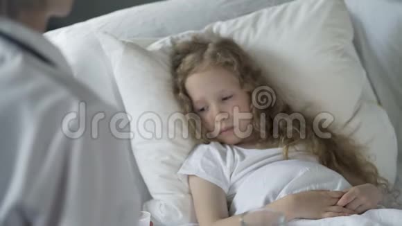 护士给免疫系统低下流感流行的不快乐的孩子吃药视频的预览图