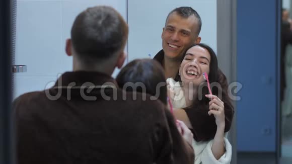 在镜子前拿着牙刷的幸福夫妻视频的预览图