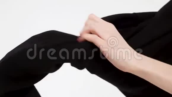 特写镜头为穿黑色连帽衫的女性手白色背景下隔离穿黑色衣服的特写过程视频的预览图