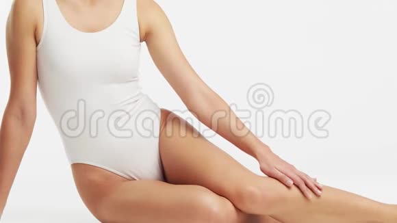 年轻美丽健康和自然的女人穿白色泳衣应用保湿霜按摩护肤脂肪视频的预览图