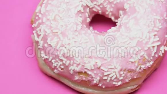 旋转粉红桌上的甜甜圈多余的糖糖尿病甜点特写视频的预览图