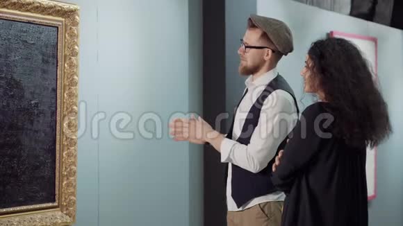 男人在画廊欣赏当代艺术品和女人交谈视频的预览图