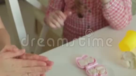 年轻的女人和女孩用橡皮泥塑造他们的牙齿在牙医中玩耍母女特写的手视频的预览图