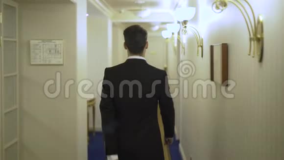 年轻的商人带着行李走进酒店大堂走进他的房间视频的预览图