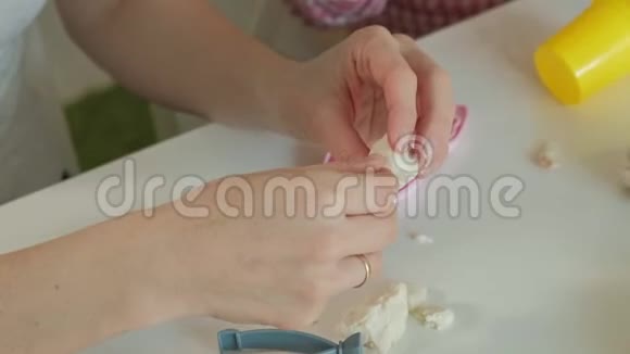 年轻的女人和女孩用橡皮泥塑造他们的牙齿在牙医中玩耍母女特写的手视频的预览图