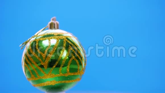 绿色圣诞球在蓝色背景下旋转视频的预览图