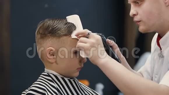 理发师为小男孩理发机器理发师用理发器和发刷理发儿童理发视频的预览图