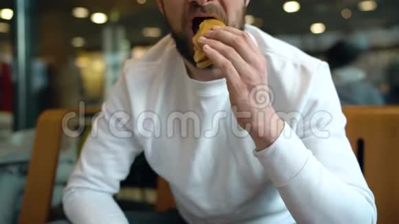 男人在咖啡馆吃汉堡视频的预览图