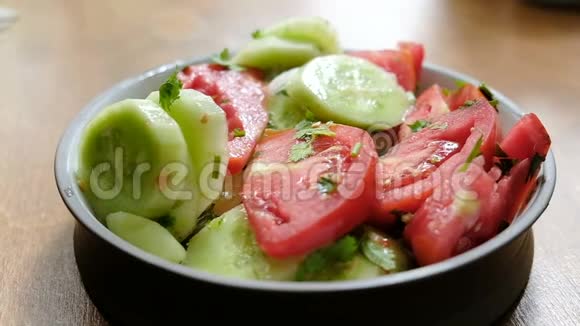 有人在叉子上串一个西红柿吃一份新鲜的生蔬菜沙拉动作缓慢适当的概念视频的预览图