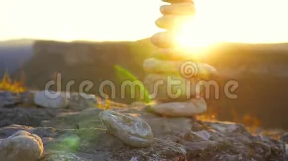日落时互相堆砌的平衡石头视频的预览图