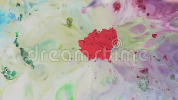水上有彩色污渍的粉末涂料带有化学多色溶液的彩色粉末在液体表面移动视频的预览图
